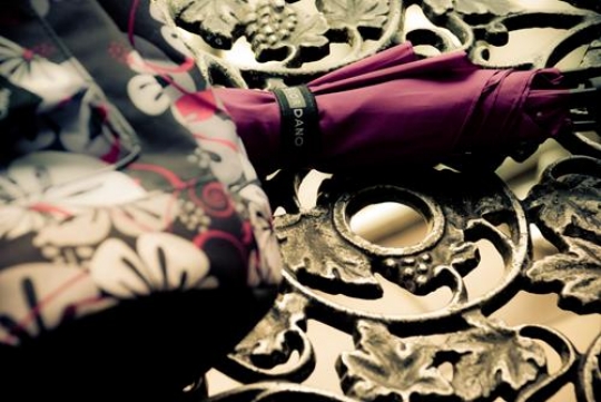 red umbrella and colorful bag on a bench