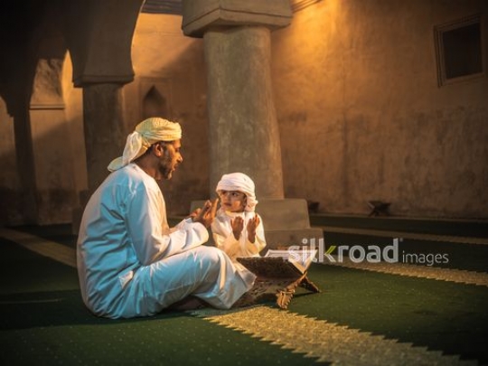 Boy praying with grandfather inside the mosque|-