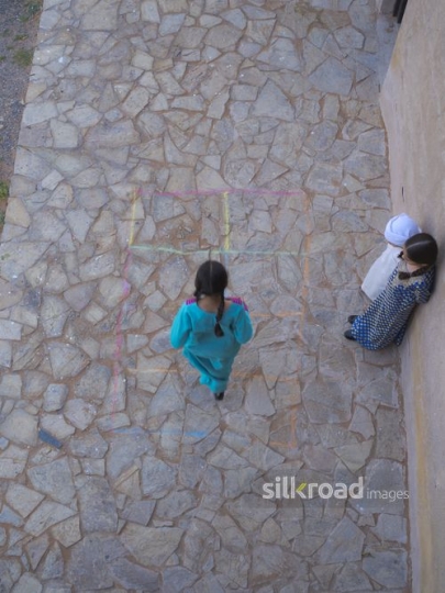 Kids playing hopscotch in the courtyard|-
