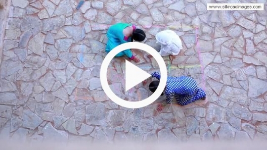 Kids sketching with chalk on the floor