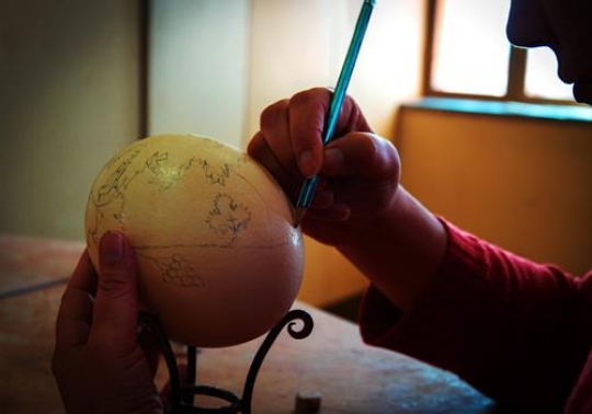 woman painting Ostrich eggs