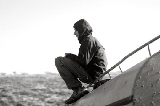 Boy sitting on water tank
