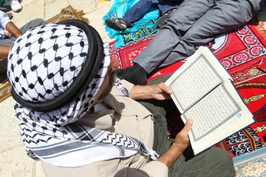 Palestinian man reading Koran
