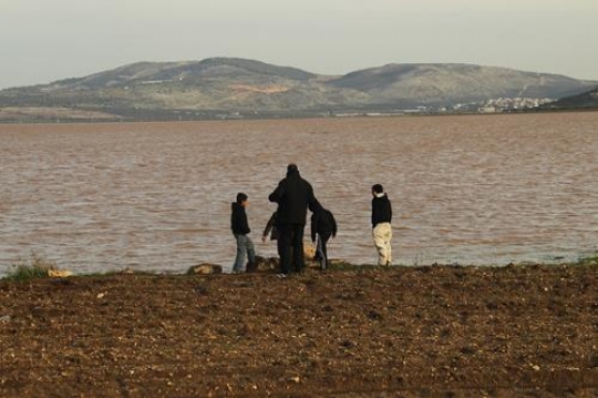Family standing next to a lake