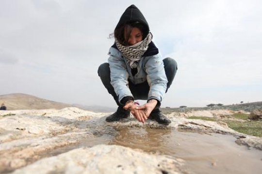 Palestinian demonstrators washing her hands at Bab al-Shams or Gate of the Sun