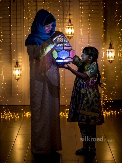 Mother and daughter  carrying lantern|-