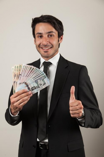 portrait of handsome man holding saudi money