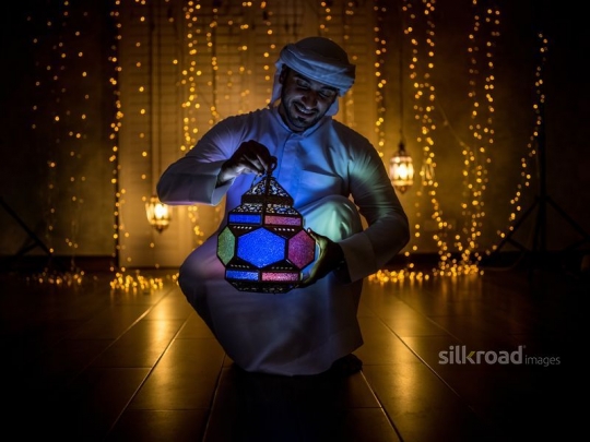 Man carrying colorful lantern|-