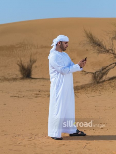 Emirati texting in the desert