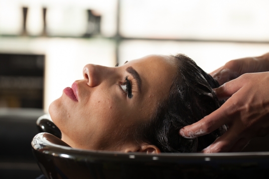 Middle Eastern woman getting her hair washed at the beauty salon|