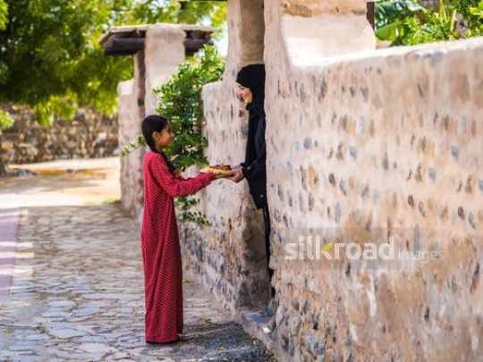 Woman taking pate from girl at the entrance|-