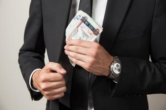 businessman putting money in his jacket pocket