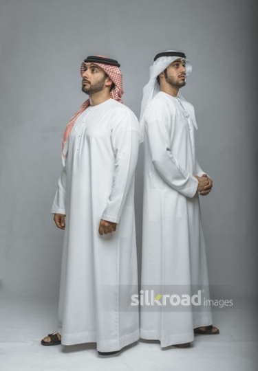 Middle Eastern men standing back to back|