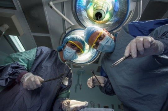 A Surgeon Holding Scissors and Cotton