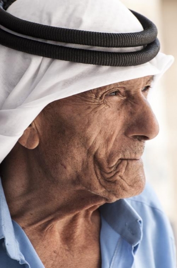 portrait of a senior man with pale eyes looking away