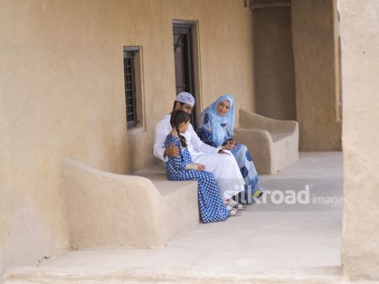 Parents sitting with kid outside|-