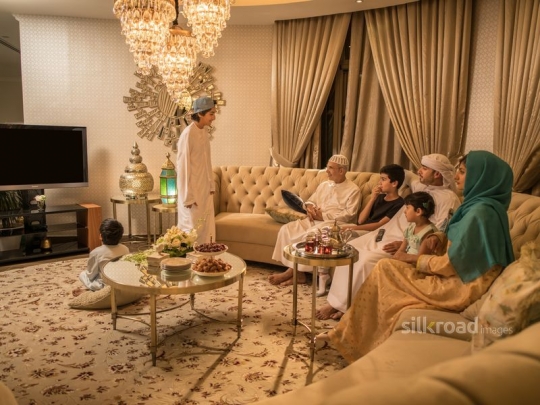 Family on sofa watching TV|-