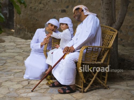Little boy taking selfie with family|-