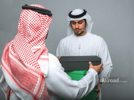 Arabian men helping each other out with moving boxes