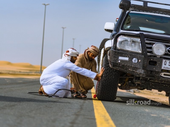 Young men fixing broken car