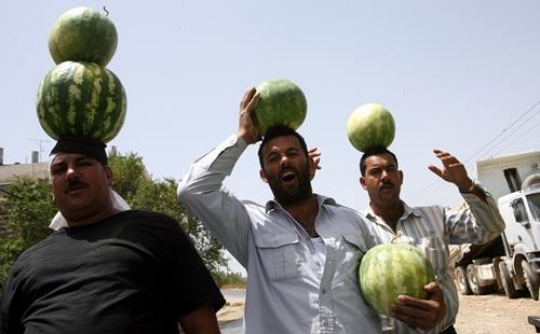 men holding watermelon on their head