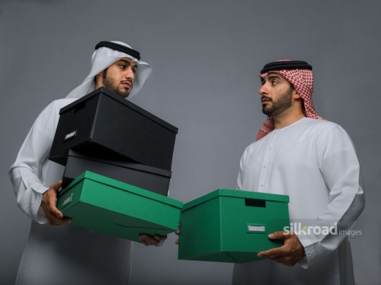 Colleagues helping each other out with moving boxes