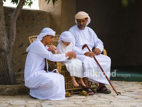 Boys checking phone with grandfather|-