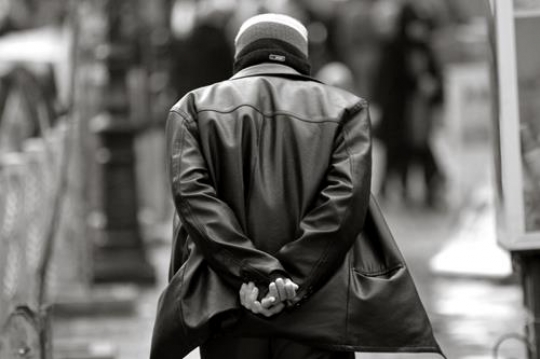 black and white image for man walking with hands behind