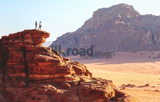 Adventure in Wadi Rum Desert, Jordan - Two People on a Cliff Overlooking the Sand Dunes
