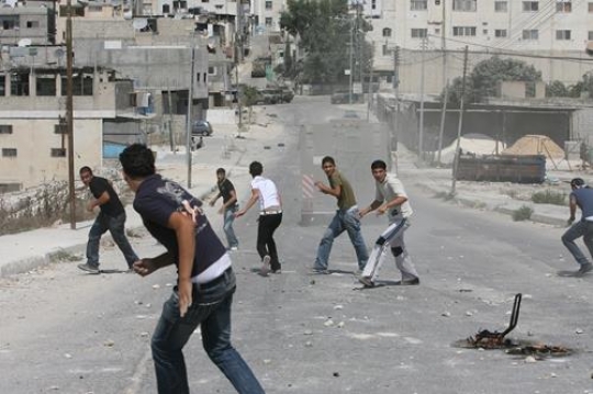 palestinian youth throwing stones at the israeli vehicle
