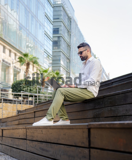 Arab Man Working Outdoors with Laptop in Amman’s Abdali Boulevard