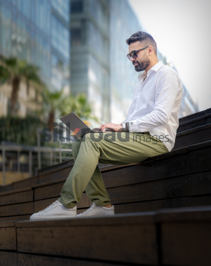 Arab Man Working Outdoors with Laptop in Amman’s Abdali Boulevard