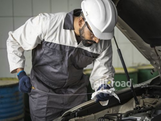 Worker checking the oil|-