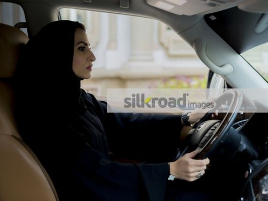 Middle Eastern Businesswoman dressed in the traditional attire sitting in the car|