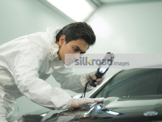 Engineer using fluorescent light on the car|