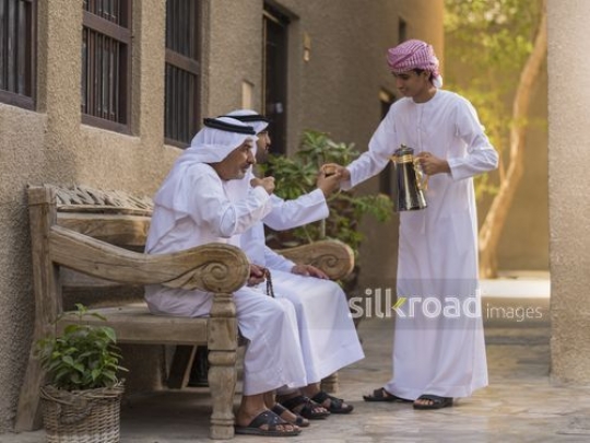 Arab son offering coffee to his grandfather and father|-