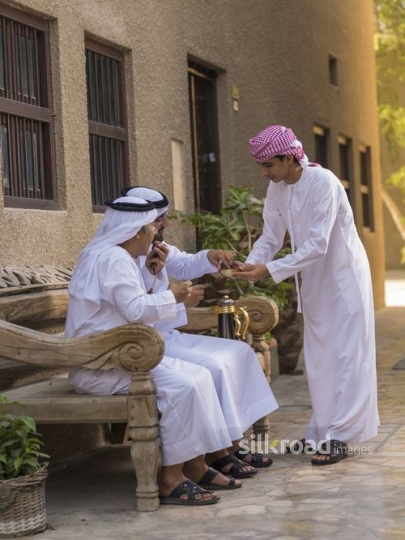 Arab son offering dates to father and grandfather|-
