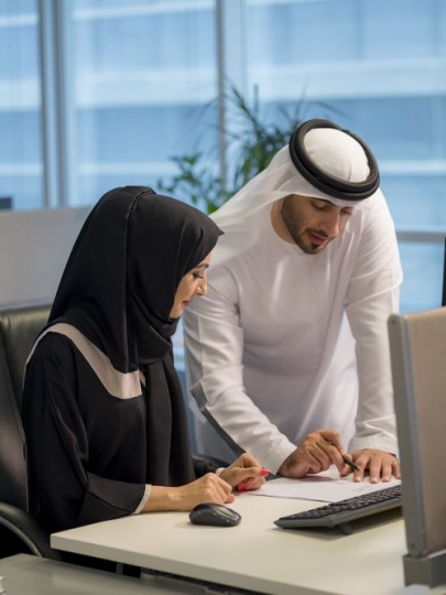 Businessman and woman sitting by the desk working together|