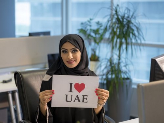 Emirati woman celebrating the UAE National Day at the office|