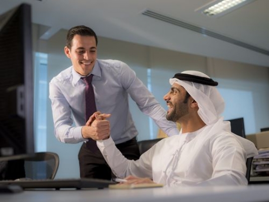 Mid shot of two business men shaking hands excited|