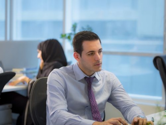 Colleague sitting by the desk|-