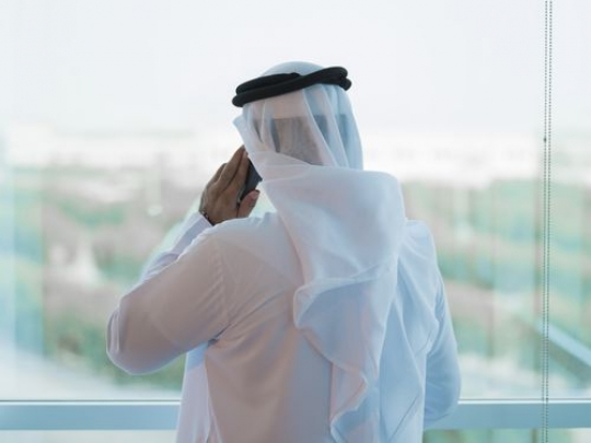 Employee standing by the window having a phone call|-