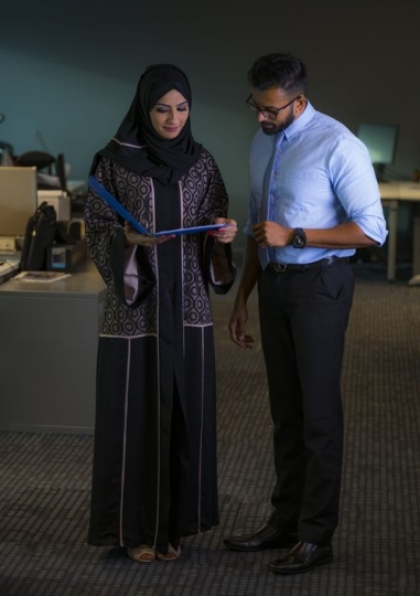 Two employees checking business file|-