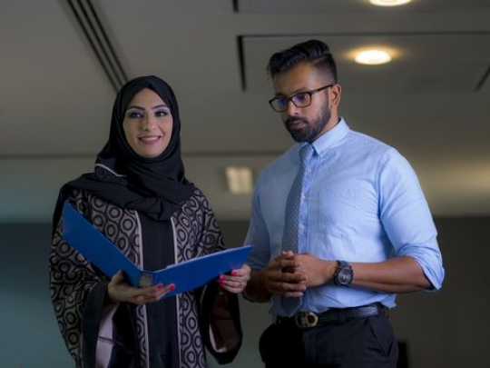 Medium shot of two business people looking at work file|-