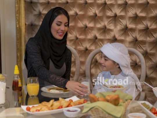 Arab woman placing milk on the table|