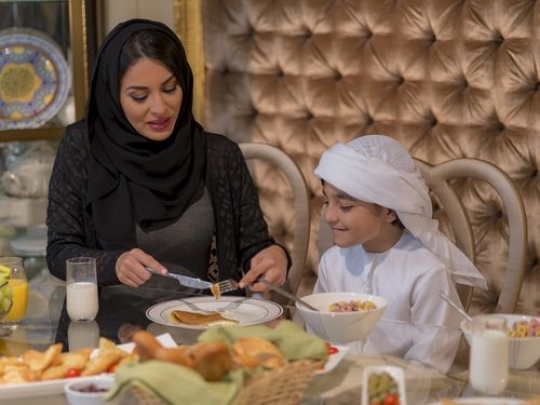 Arab mother and son eating|-