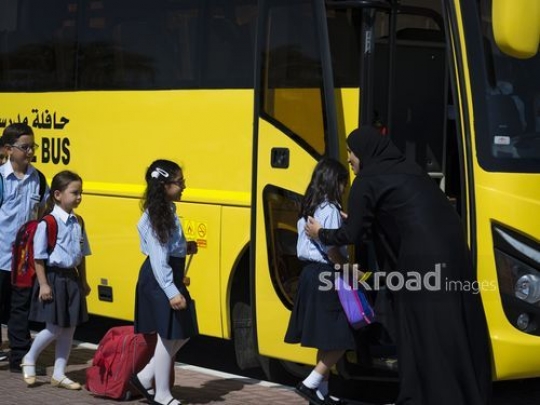 Young kids getting on the school bus |-