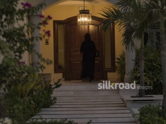 Middle Eastern woman entering the house|