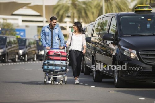 Man and Woman walking together with their luggage|-
