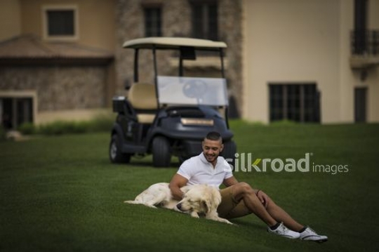 Middle Eastern man sitting down with the dog next to him|-